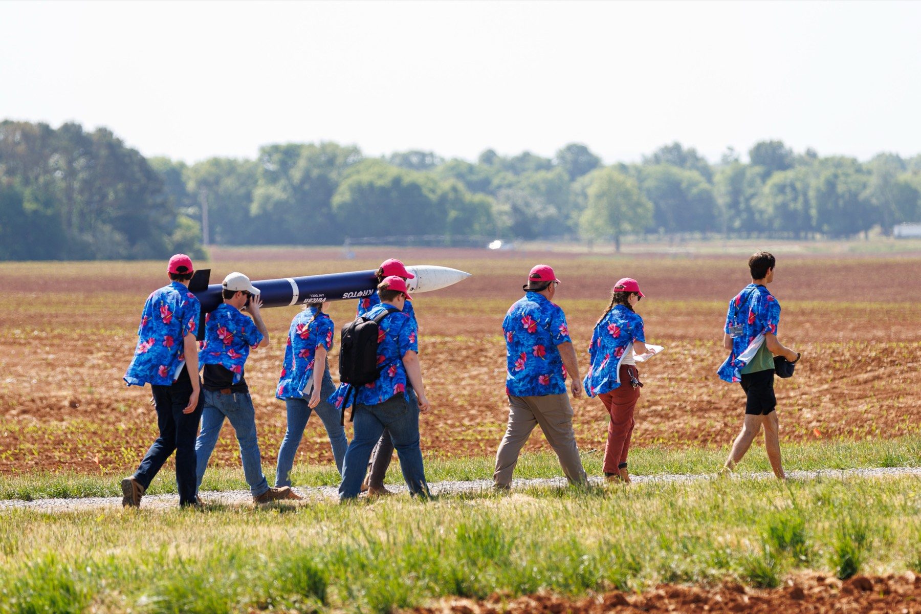 AURA members carrying Bedrock across the field at NASA Student Launch